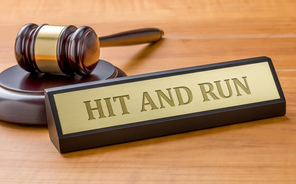A gavel rests beside a nameplate engraved with the words "Hit and Run," symbolizing justice and legal proceedings related to such incidents.
