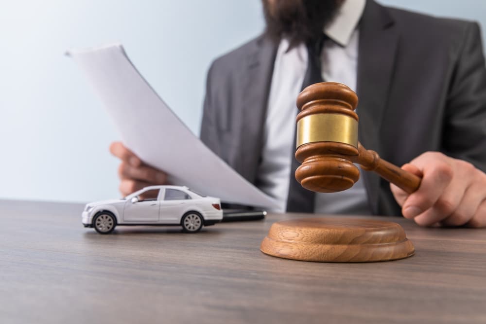 A model car alongside a gavel symbolizes legal proceedings related to car accidents, including lawsuits and insurance claims.