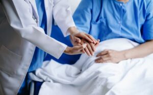 A compassionate medical doctor holds the patient's hands, offering genuine support and comfort.