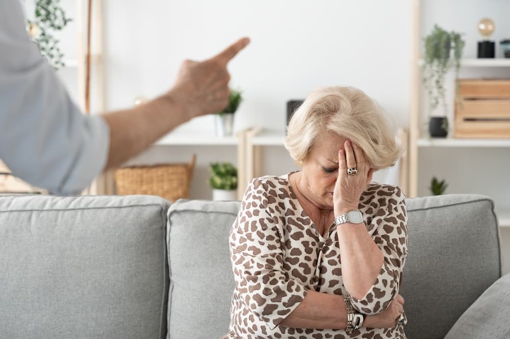 A distressed woman sits in anguish after experiencing emotional and verbal abuse in a nursing home, reflecting the trauma and suffering endured by victims.