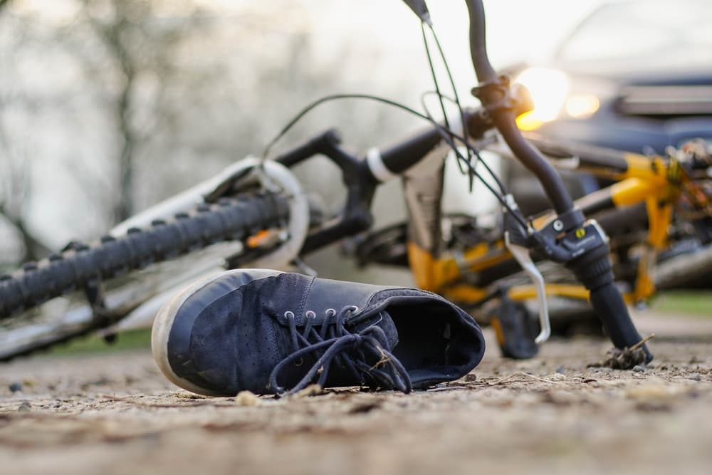 Close-up of a sneakers on the road near bicycle after an accident.