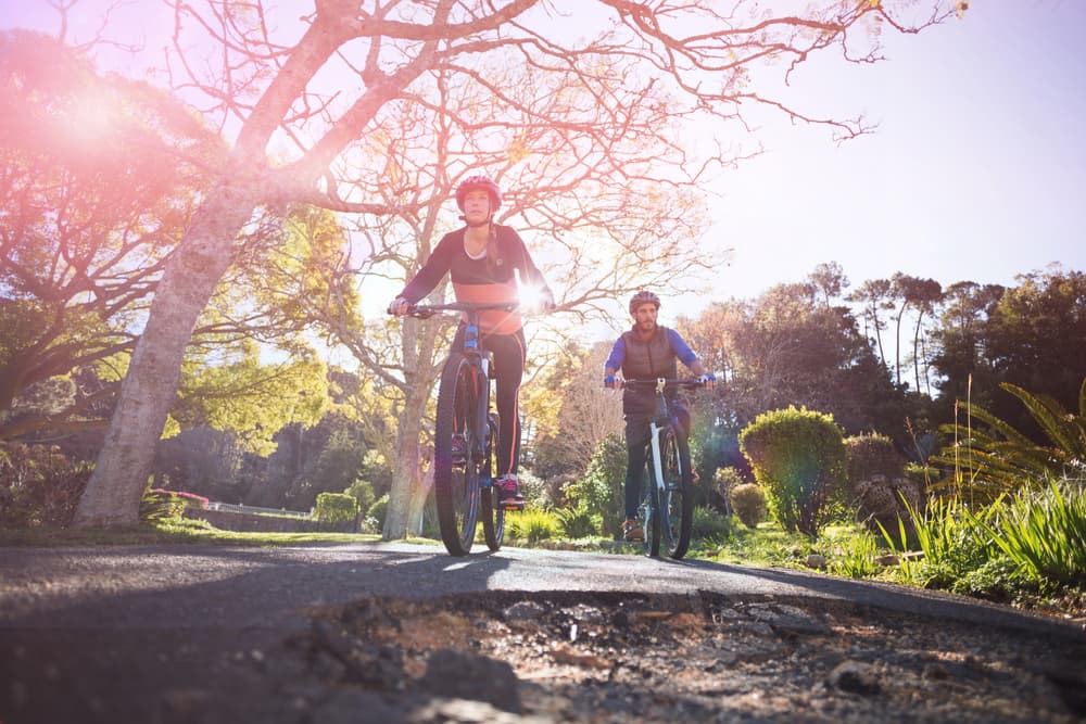 biker couple cycling on countryside road