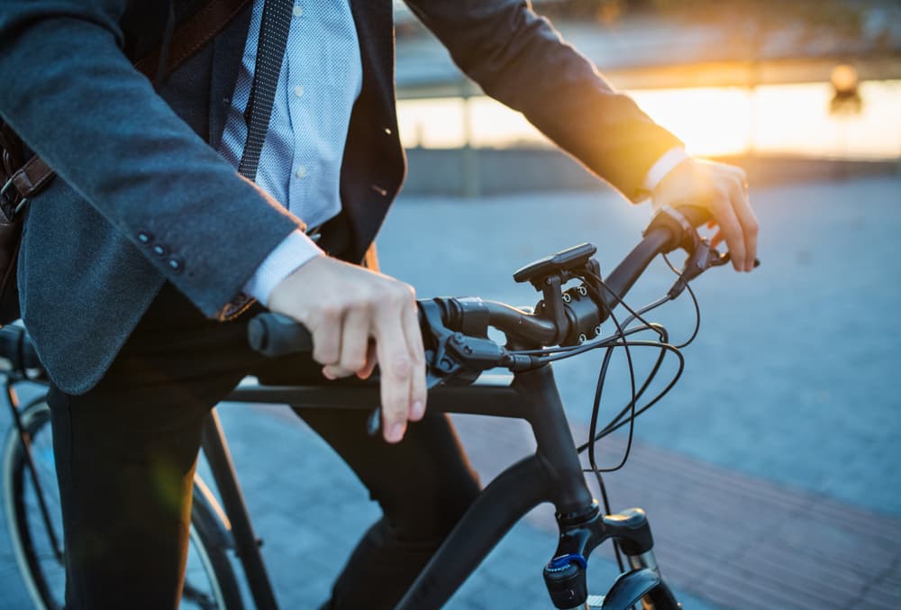 A businessman commuter with electric bicycle traveling from work in city.