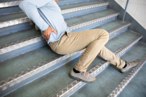 Mature man lying on a staircase after a slip and fall accident, illustrating injury and potential premises liability