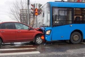 Frontal head-on collision between a bus and a car, showing severe damage from a traffic accident
