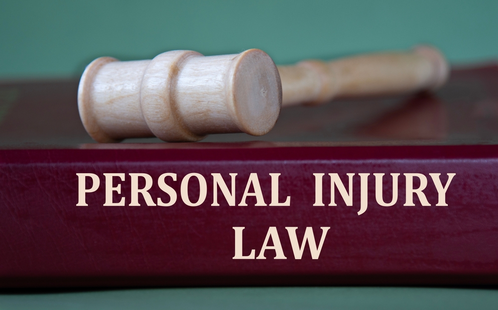 Burgundy folder labeled 'Personal Injury Law' placed beside a judge's gavel, representing legal matters in injury cases.
